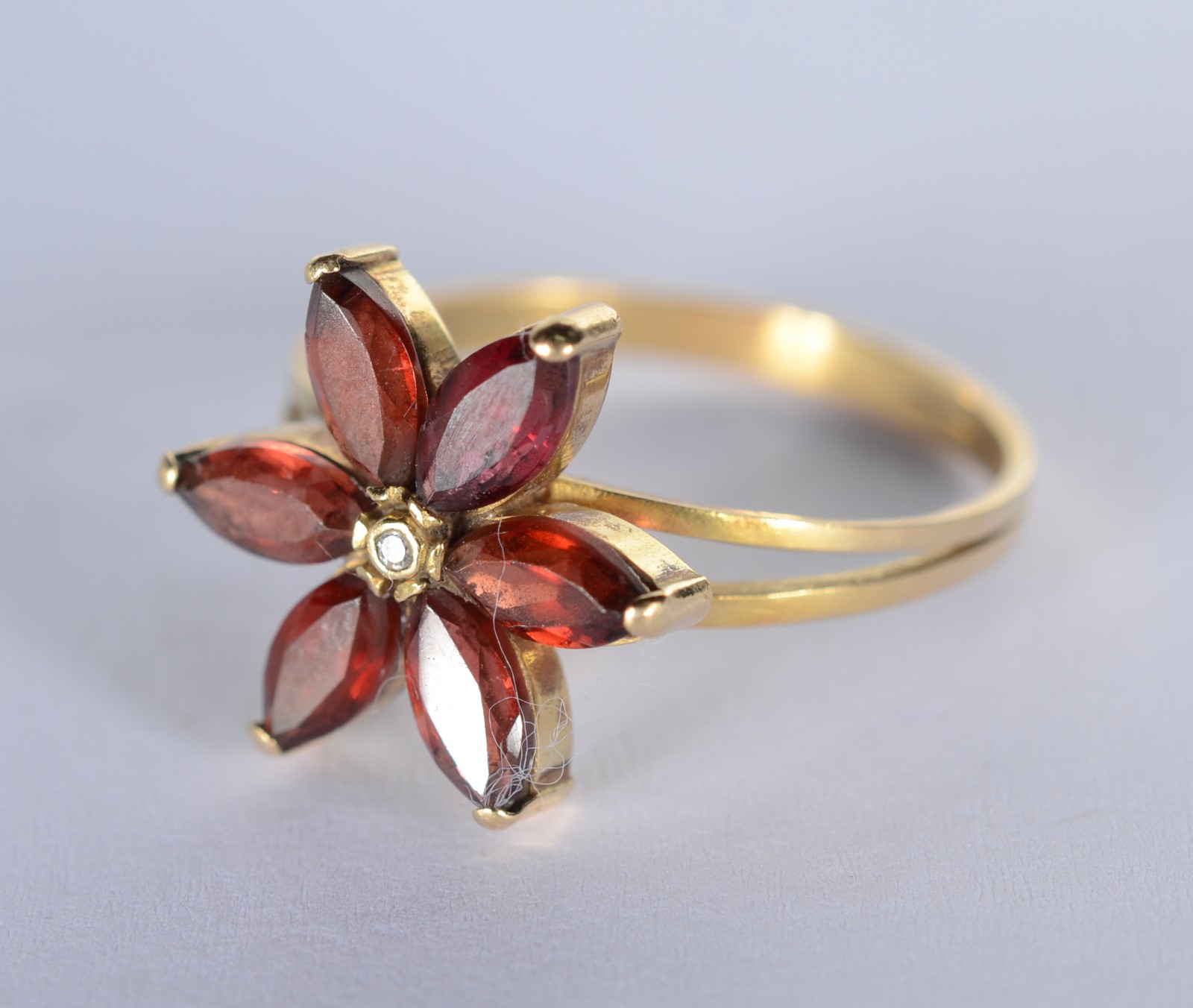 Anel de ouro 18 k., contraste 750 mls feitio flor com pedras e um... - foto 2 de 4