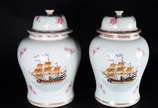 Par de potiches de porcelana decorados com figu... - Par de potiches de porcelana decorados com figuras de navios em policromia e flores cor de rosa. Tampa de um dos potiches com  fio de cabelo.