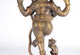 Ganesha com mangusto - Escultura de bronze dourado representando o Deus Ganesha. É representado por um elefante, onde a cabeça simboliza a felicidade, as orelhas abertas são