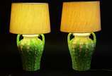 Par de abatjoures de cerâmica decorada com folh... - Par de abatjoures de cerâmica decorada com folhas verdes em relevo, cúpulas de tecido na cor bege.