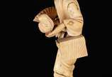 Escultura de marfim chines representando figura... - Escultura de marfim chines representando figura típica com leque e cesto. Pequenos defeitos.
