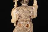 Netsuke de marfim oriental representando figura... - Netsuke de marfim oriental representando figura masculina com kimono e espada. Assinado.