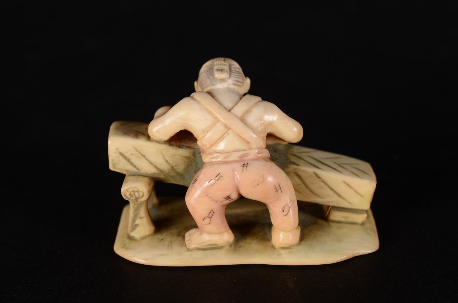 Netsuke de marfim oriental representando figura masculina em sua mesa... - foto 2 de 4