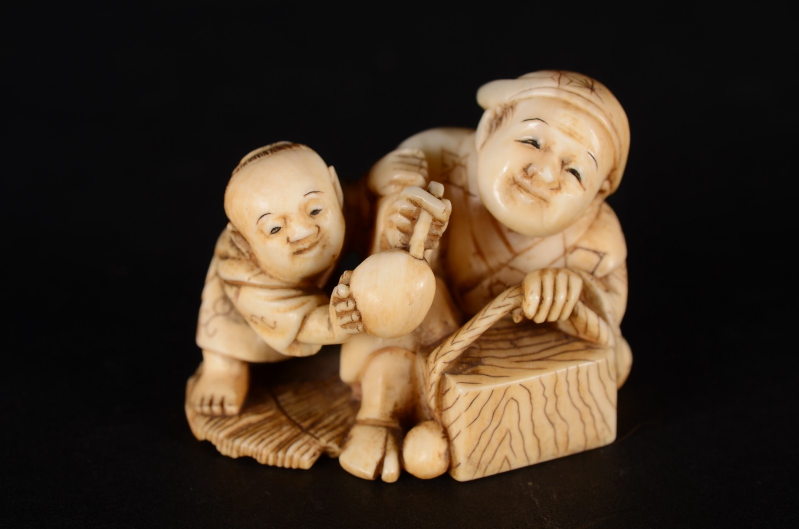 Netsuke de marfim oriental representando figura com cesto e criança... - foto 1 de 4
