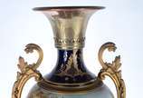 Ânfora de porcelana francesa azul cobalto e dou... - Ânfora de porcelana francesa azul cobalto e dourado, decorada com cena romântica e paisagem em policromia, guarnição de bronze. Ligeiramente inc...