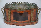 Cachepot vitoriano de madeira parquetada com in... - Cachepot vitoriano de madeira parquetada com interior de metal. Medidas 42 x 27 cm e altura 19 cm (parte inferior com folheado da madeira soltan...
