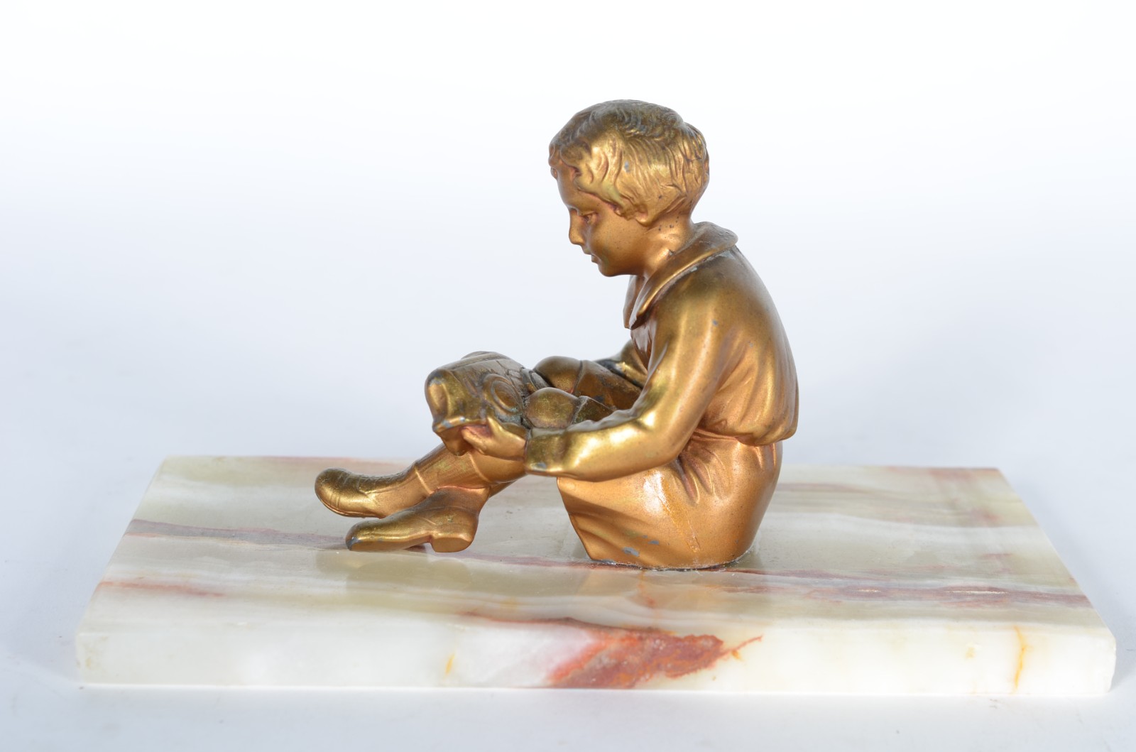 Escultura de metal dourado representando menino segurando carrinho... - foto 4 de 5