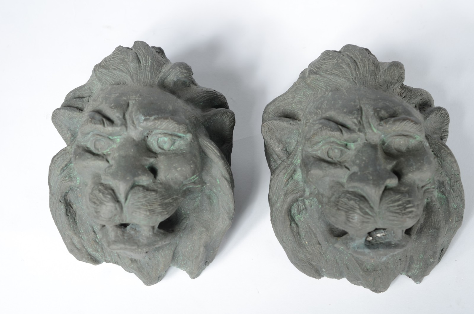 Par de esculturas de bronze na forma de caras de animais. - foto 1 de 2