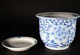 Cachepot com prato de porcelana oriental azul e... - Cachepot com prato de porcelana oriental azul e branca (fio de cabelo no fundo).
