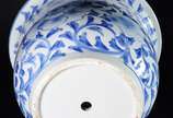 Cachepot com prato de porcelana oriental azul e... - Cachepot com prato de porcelana oriental azul e branca (fio de cabelo no fundo).