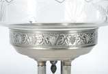 Fruteira com base de metal prateado decorado co... - Fruteira com base de metal prateado decorado com folhas de parreira e cachos de uvas em relevo, base quadrangular com quatro colunas sustentando...