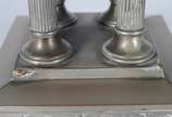 Fruteira com base de metal prateado decorado co... - Fruteira com base de metal prateado decorado com folhas de parreira e cachos de uvas em relevo, base quadrangular com quatro colunas sustentando...