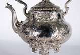 Samovar Art Nouveau de metal prateado ingles, c... - Samovar Art Nouveau de metal prateado ingles, contrastado, trabalhado com folhagens em relevo. Pega da tampa na forma de pássaro. Desgastes.
