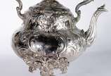 Samovar Art Nouveau de metal prateado ingles, c... - Samovar Art Nouveau de metal prateado ingles, contrastado, trabalhado com folhagens em relevo. Pega da tampa na forma de pássaro. Desgastes.
