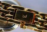 Bulova (1875),  - Relógio feminino de metal dourado e detalhes em  metal, mostrador branco com números e ponteiros dourados. Na caixa, funcionando.