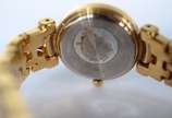 Bulova (1875),  - Relógio feminino de metal dourado e detalhes em  metal, mostrador branco com números e ponteiros dourados. Na caixa, funcionando.