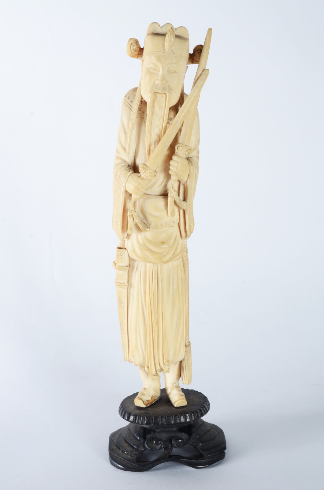 Escultura de marfim representando figura masculina segurando espadas... - foto 1 de 8