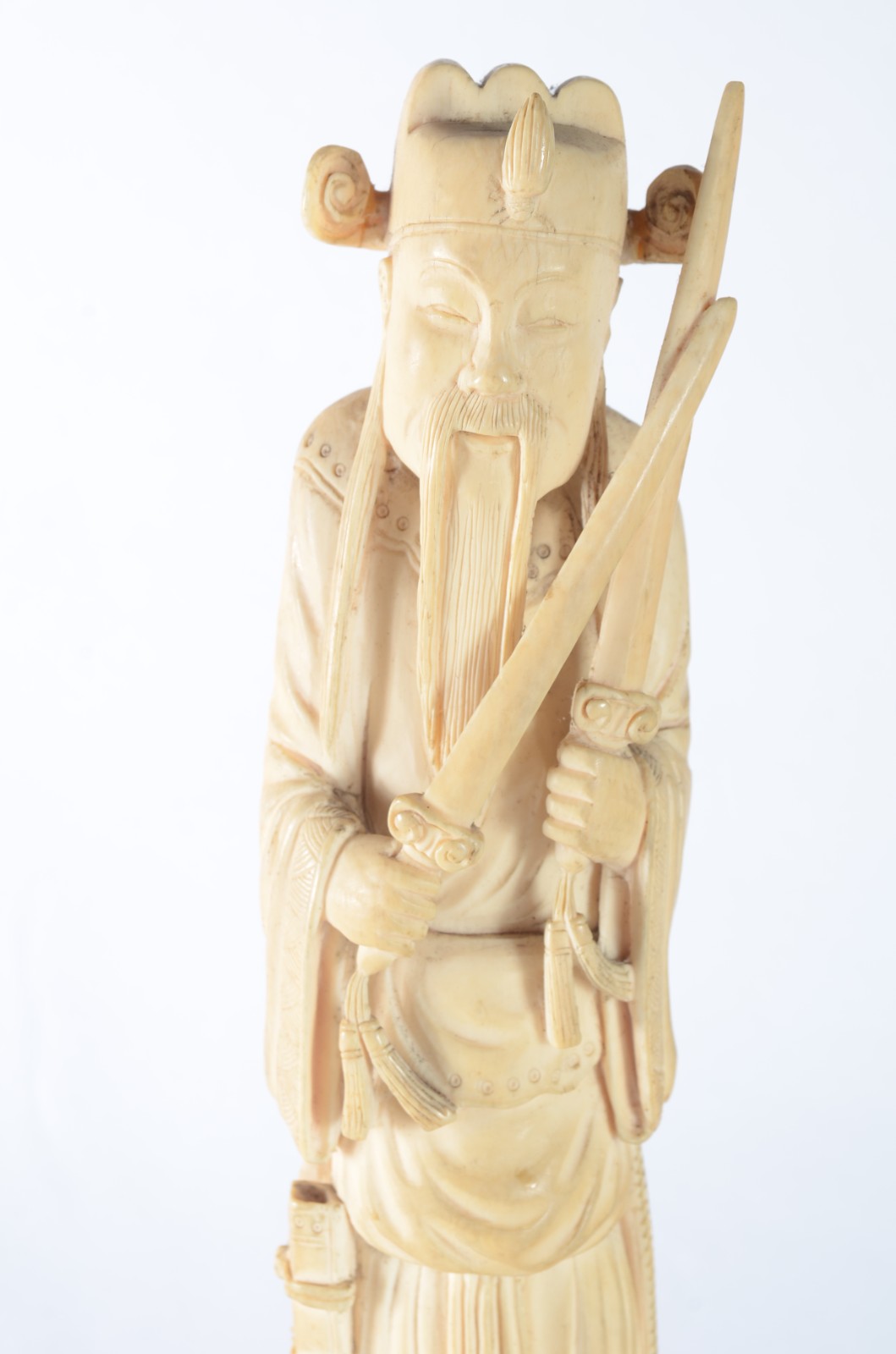 Escultura de marfim representando figura masculina segurando espadas... - foto 2 de 8