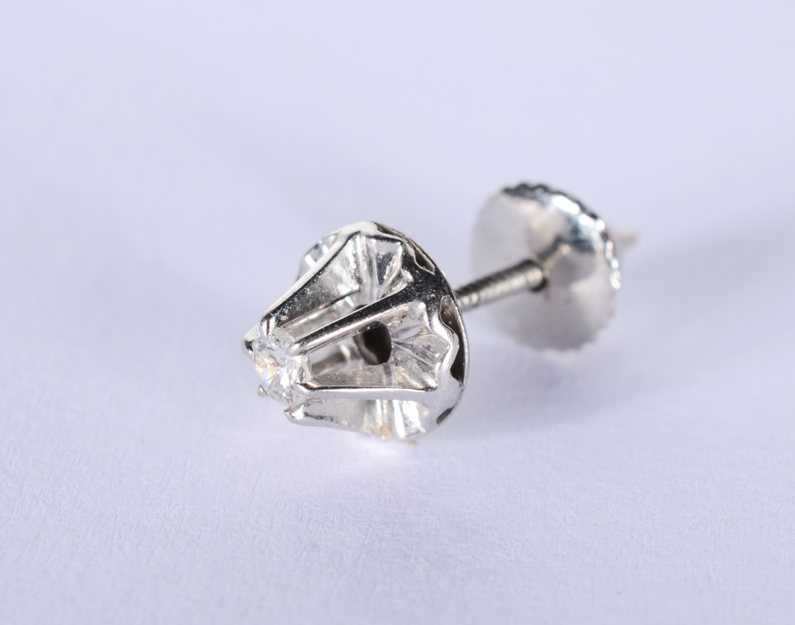 Um brinco de ouro branco com um brilhante de 0,07 ct. (Por motivos de... - foto 4 de 7