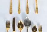 Faqueiro de metal dourado, composto de: 10 colh... - Faqueiro de metal dourado, composto de: 10 colheres, 9 garfos, 10 facas grandes; 23 colheres, 10 garfos para sobremesa e 6 peças de servir. Tota...