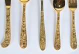 Faqueiro de metal dourado, composto de: 10 colh... - Faqueiro de metal dourado, composto de: 10 colheres, 9 garfos, 10 facas grandes; 23 colheres, 10 garfos para sobremesa e 6 peças de servir. Tota...