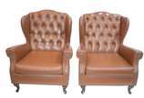 Par de poltronas "bergere" estofadas e forradas... - Par de poltronas "bergere" estofadas e forradas em curvim marrom e tacheados, encostos em capitoné, pés de madeira, estilo Chipendale. Desgastes...