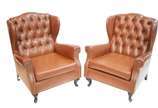 Par de poltronas "bergere" estofadas e forradas... - Par de poltronas "bergere" estofadas e forradas em curvim marrom e tacheados, encostos em capitoné, pés de madeira, estilo Chipendale. Desgastes...