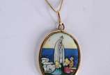 Colar  com pendente representando Nossa Senhora... - Colar  com pendente representando Nossa Senhora de Fátima e os Pastorinhos de ouro 18 k., contraste 750 mls. (Por motivos de segurança a peça nã...