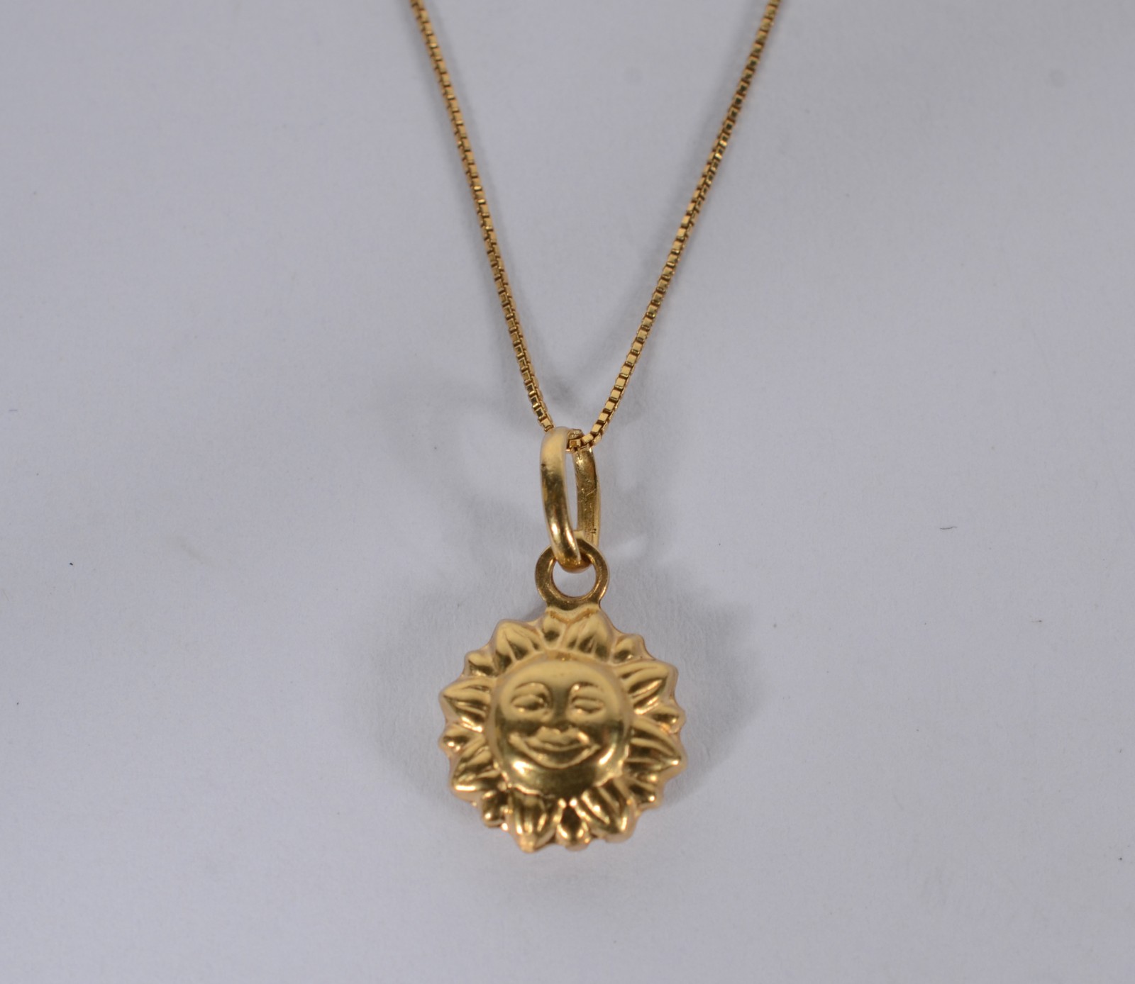 Colar com pendente feitio "sol" de ouro 18 k., contraste 750 mls... - foto 1 de 5
