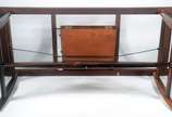 Sérgio Rodrigues (1927-2014), Mesa Burton - Mesa de jantar de madeira nobre, pés de madeira maciça ligados por haste de latão, tampo folheado com tábua extensora medindo 1.00 m. x 0,50 cm. Anos 