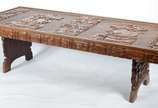 Mesa de centro de madeira entalhada com perfis ... - Mesa de centro de madeira entalhada com perfis de rostos masculinos, pernas recortadas. Desgastes.
