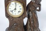 Ansonia Clock Company (1851-2006),  - Relógio americano de mesa de petit bronze, com pátina marrom, estilo ART NOUVEAU. Peça representando figura feminina. Decoração representado garça, fl
