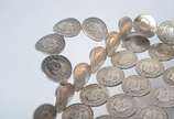 Bandeja formada por moedas de prata baixa de 2.... - Bandeja formada por moedas de prata baixa de 2.000 reis, datadas da década de 1920/30, alças laterais. Peso da prata: 630 g. Um pé solto. (Por m...