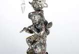 Par de luminárias de metal prateado decorados c... - Par de luminárias de metal prateado decorados com figuras de flautistas sobre pedestal. Um deles com manga de cristal. Faltando alguns pingentes...