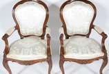 Par de elegantes cadeiras com braços de madeira... - Par de elegantes cadeiras com braços de madeira nobre, estilo Luis XV, estofamento recém feito forrado com tecido bege adamascado.