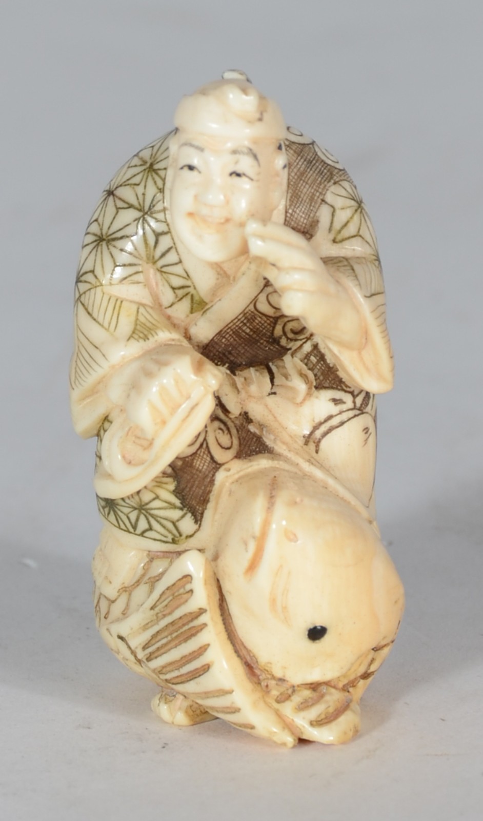 Netsuke de marfim oriental representando figura sobre peixe. - foto 1 de 5
