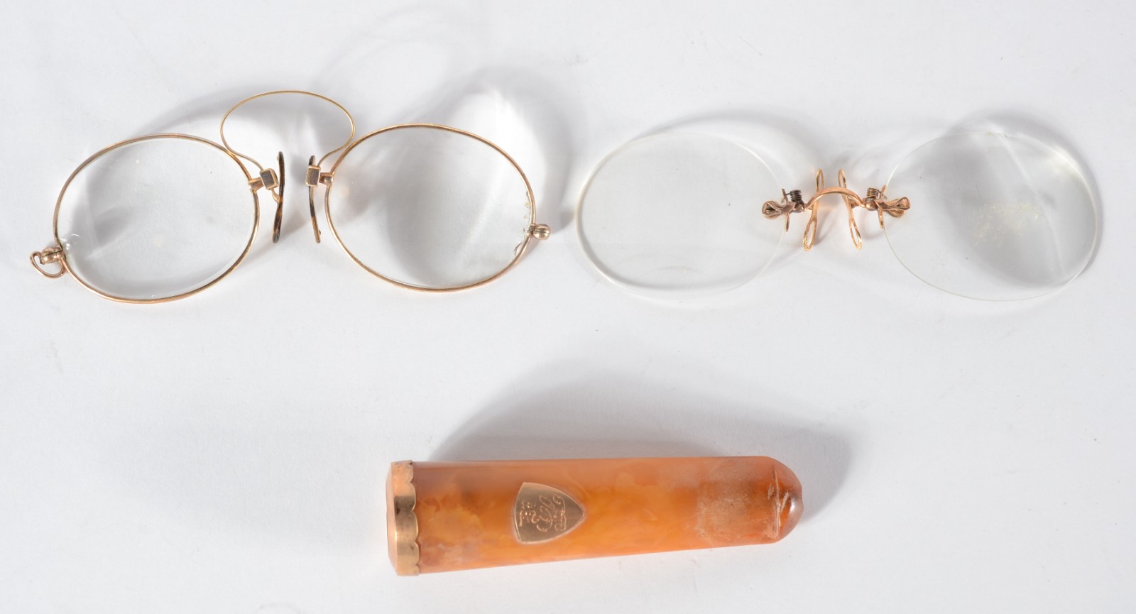 Três peças, sendo: dois pince nez e uma piteira de âmbar com detalhes... - foto 1 de 7