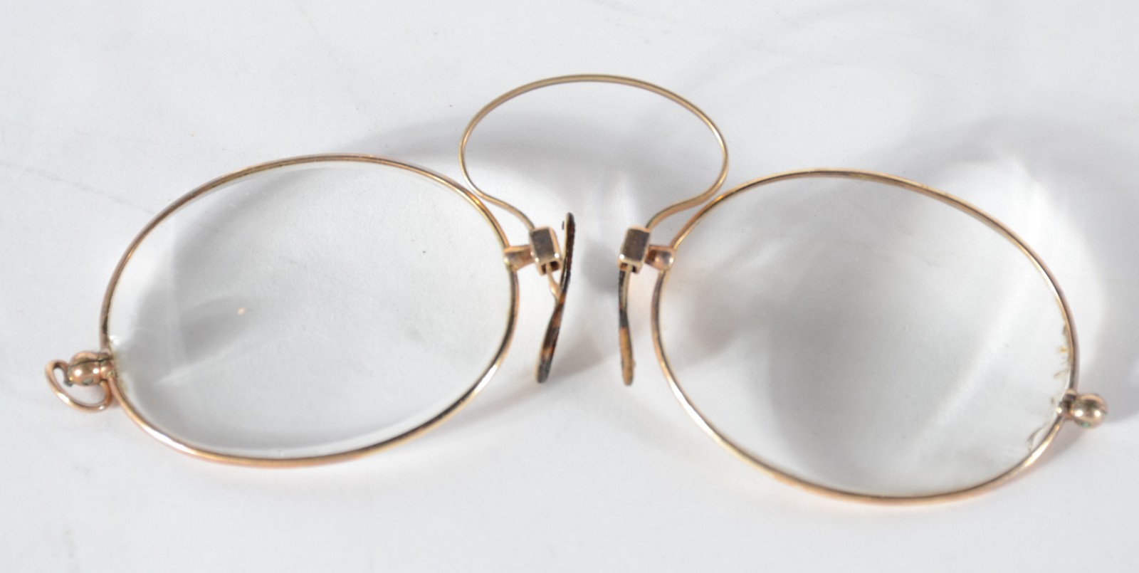 Três peças, sendo: dois pince nez e uma piteira de âmbar com detalhes... - foto 2 de 7