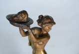 Franz Xaver Bergmann (1861-1936), Salomé - Escultura de bronze representando "Salomé" nua com os braços estendidos segurando a cabeça de João Batista em uma bandeja. Assinada N.Greb. Base de má