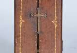 Oratório de viagem de madeira revestido em cour... - Oratório de viagem de madeira revestido em couro pirogravado com Imagem de Santa Terezinha em marfim. Século XIX. Desgastes do tempo.