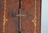 Oratório de viagem de madeira revestido em cour... - Oratório de viagem de madeira revestido em couro pirogravado com Imagem de Santa Terezinha em marfim. Século XIX. Desgastes do tempo.