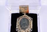 Pendente antigo de platina com representação do... - Pendente antigo de platina com representação do Sagrado Coração de Jesus envolta com perolas, brilhantes e pedras azuis.