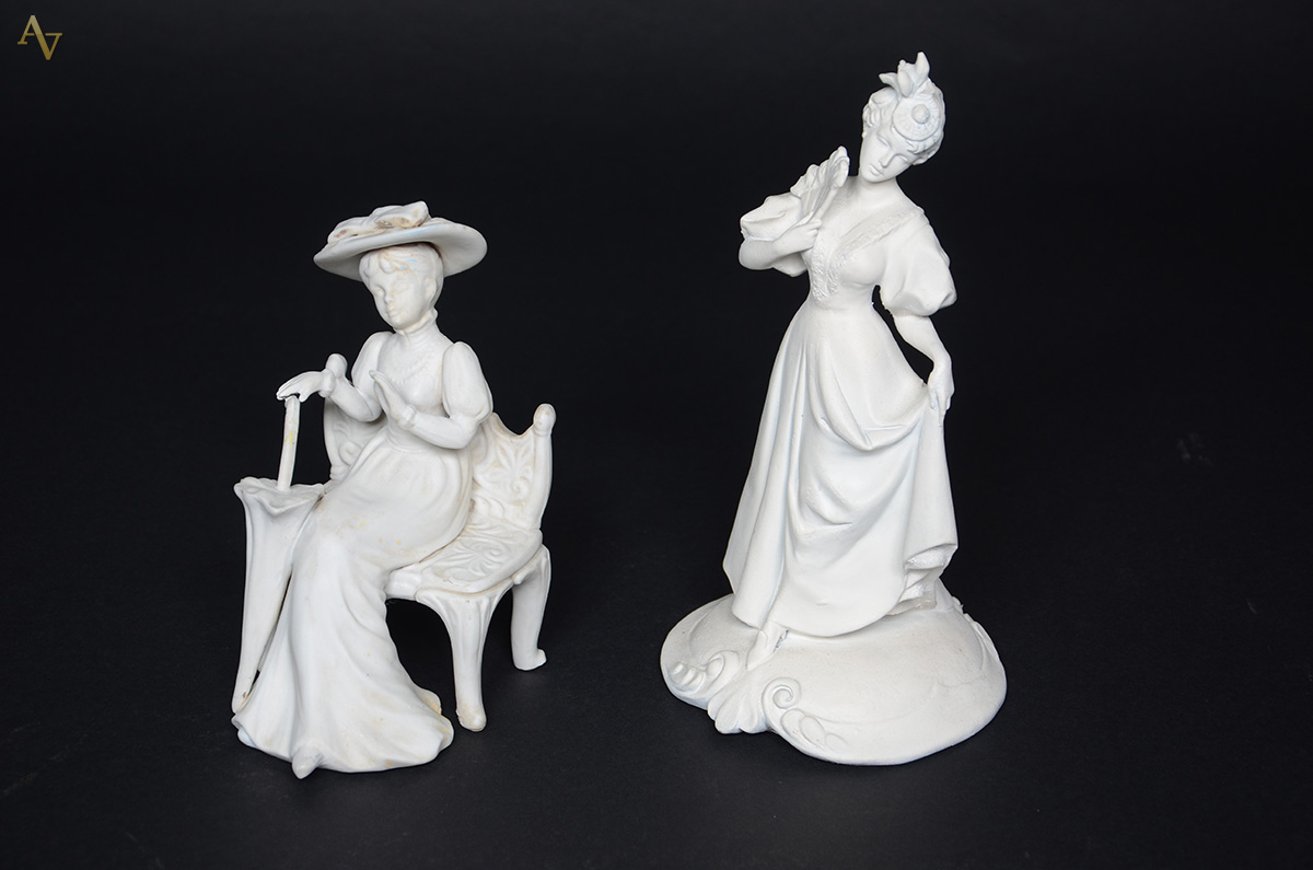 Duas esculturas de biscuit representando figuras femininas, uma com...