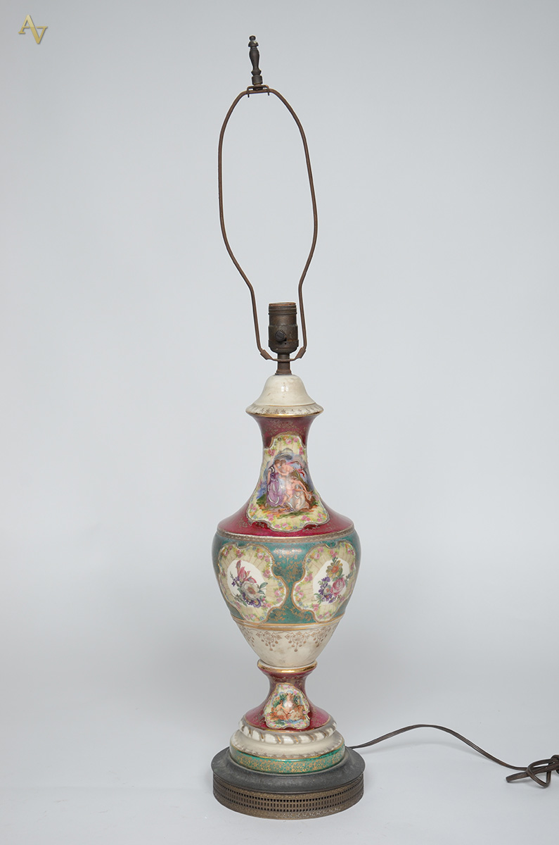 Abajour de porcelana com cena romântica em policromia. Altura 87 cm.