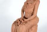 VALMIR NEVES,  - Escultura em barro cozido representando figura feminina sentada com flores no colo.