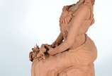 VALMIR NEVES,  - Escultura em barro cozido representando figura feminina sentada com flores no colo.