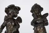 Par de antigas esculturas de petit bronze, repr... - Par de antigas esculturas de petit bronze, representando casal de crianças anjos, sobre pedestais com flores em relevo. Desgastes no metal.