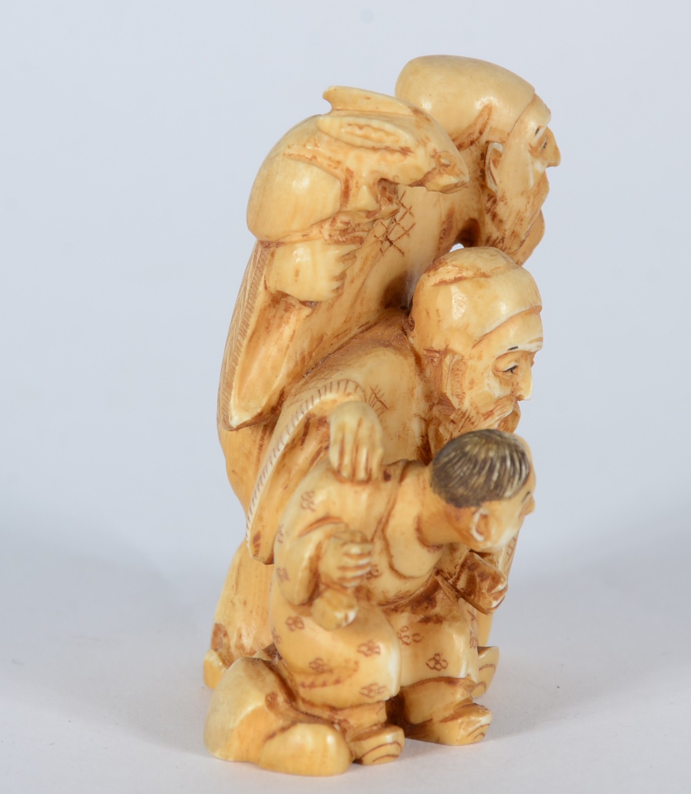 Netsuke de marfim representando tres figuras, assinado. - foto 2 de 5