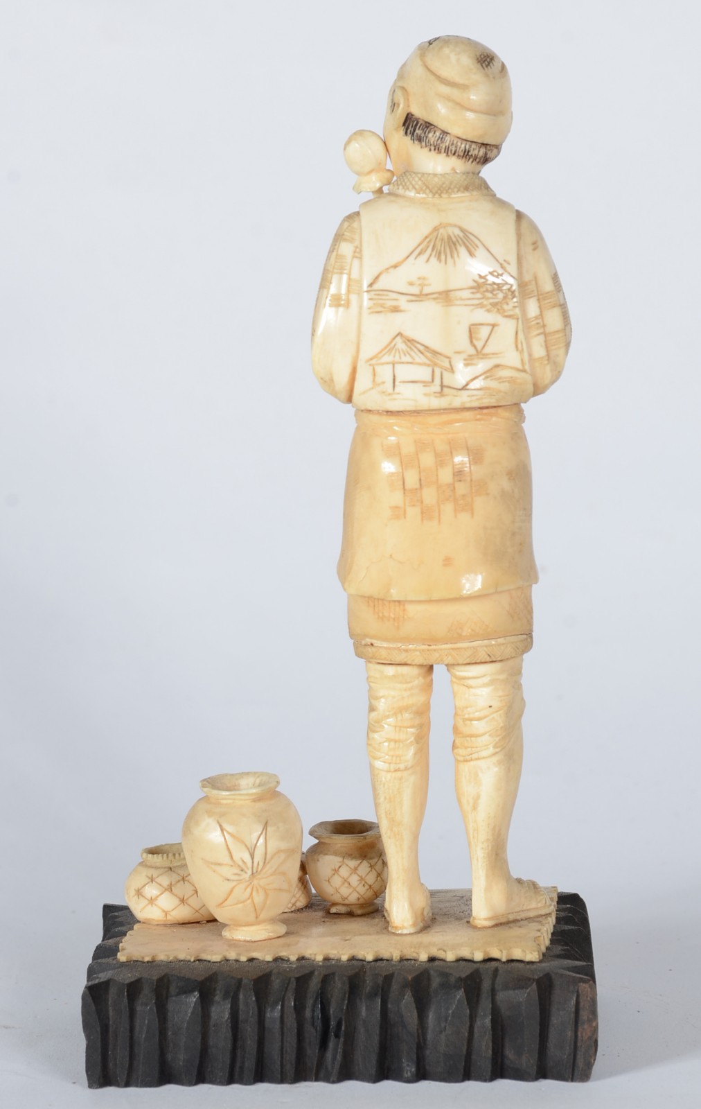 Estatueta de marfim representando figura masculina com potes, base de... - foto 4 de 5