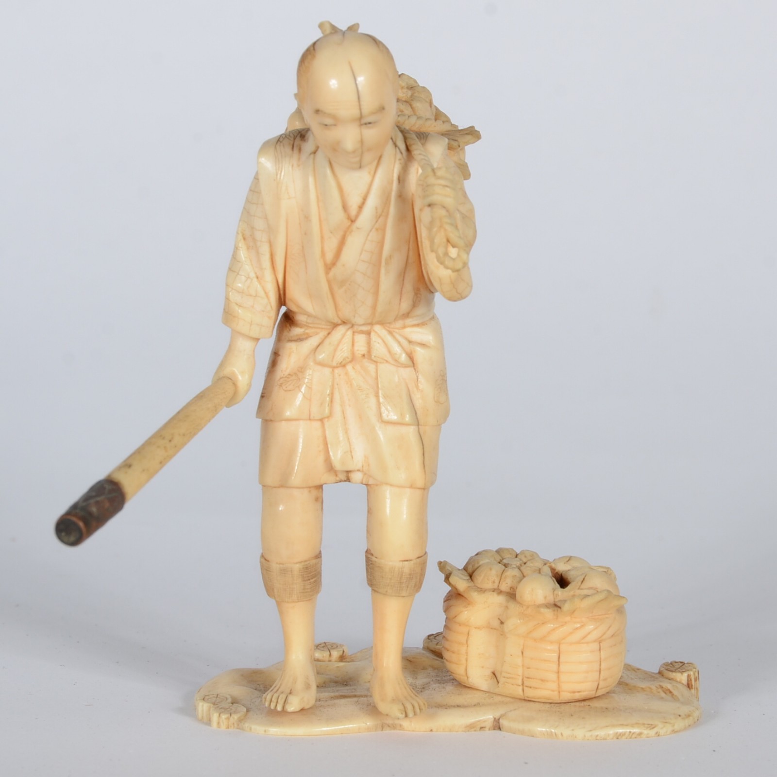 Estatueta de marfim representando figura masculina com cesto de... - foto 1 de 5